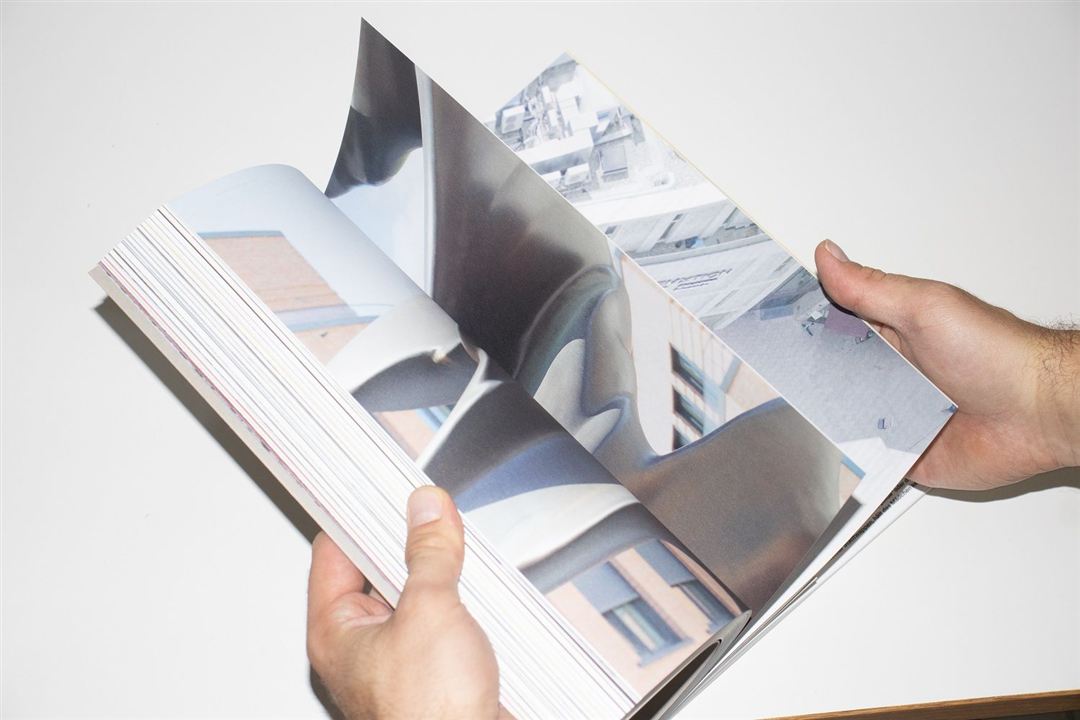 Geöffnet Kunstkatalog wird von zwei Händen gehalten.